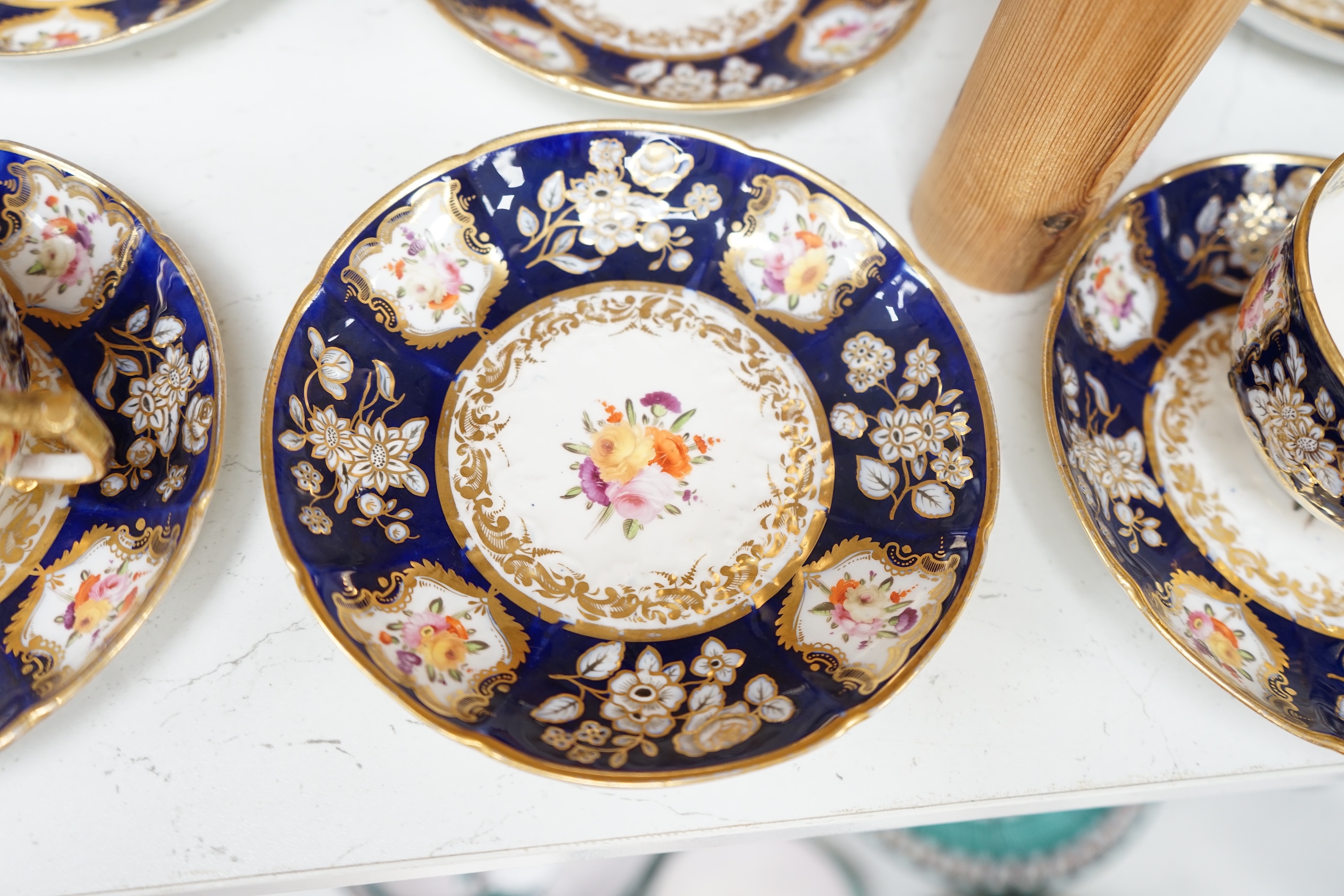 An early 19th century English porcelain tea service, possibly Coalport, moulded in low relief with floral reserves and cobalt blue border. Condition - varies